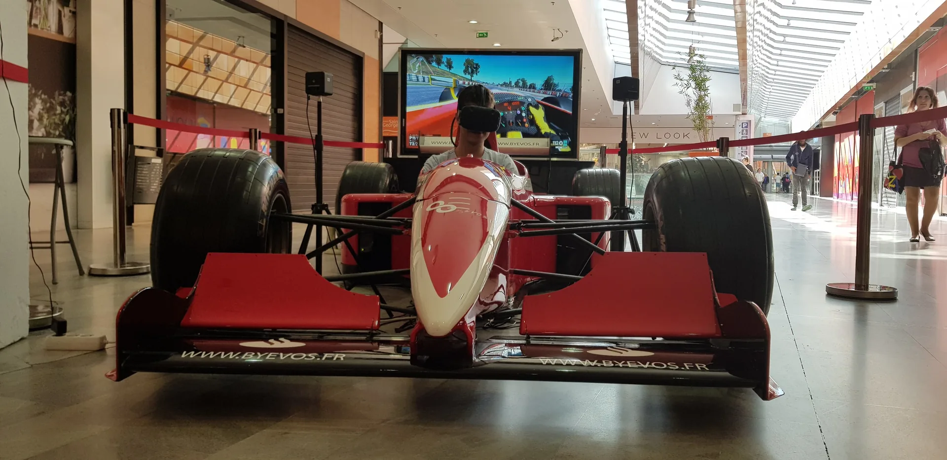 Personne en casque VR au volant d'une monoplace rouge